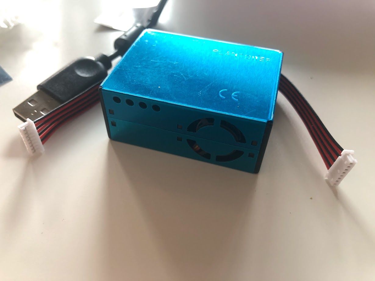 My PMS5003 air quality sensor on my desk. It's blue, with 6-wire cable.