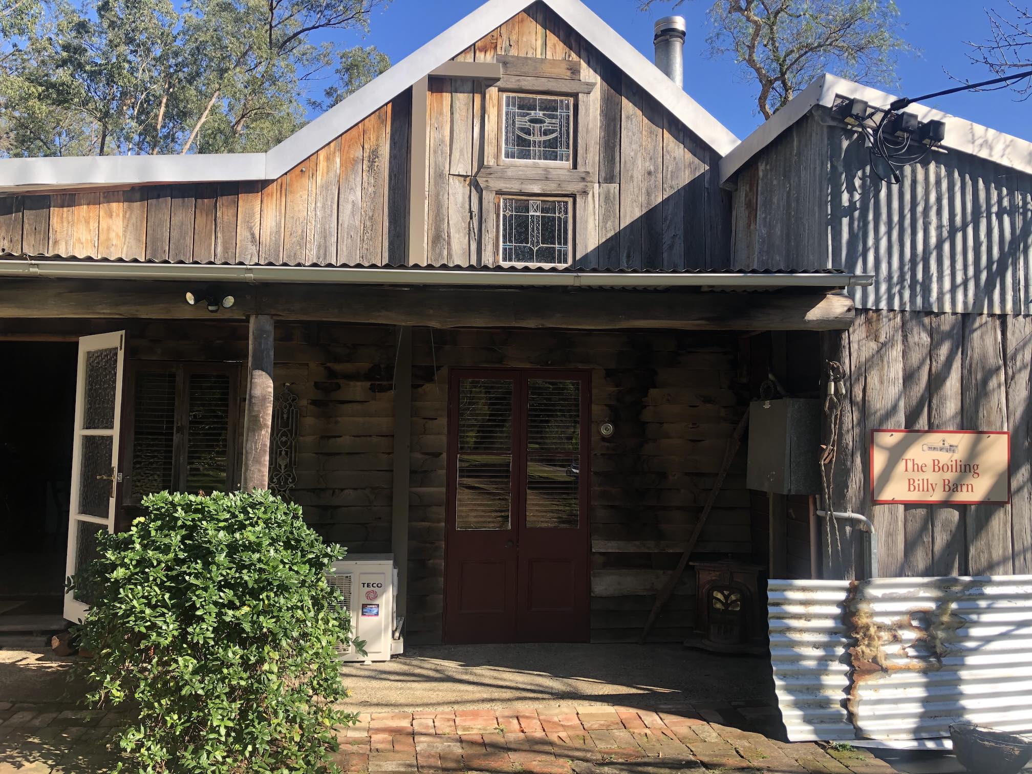 Wooden barn, with loft window, made of mostly wood and some corrugated iron. Very rustic.