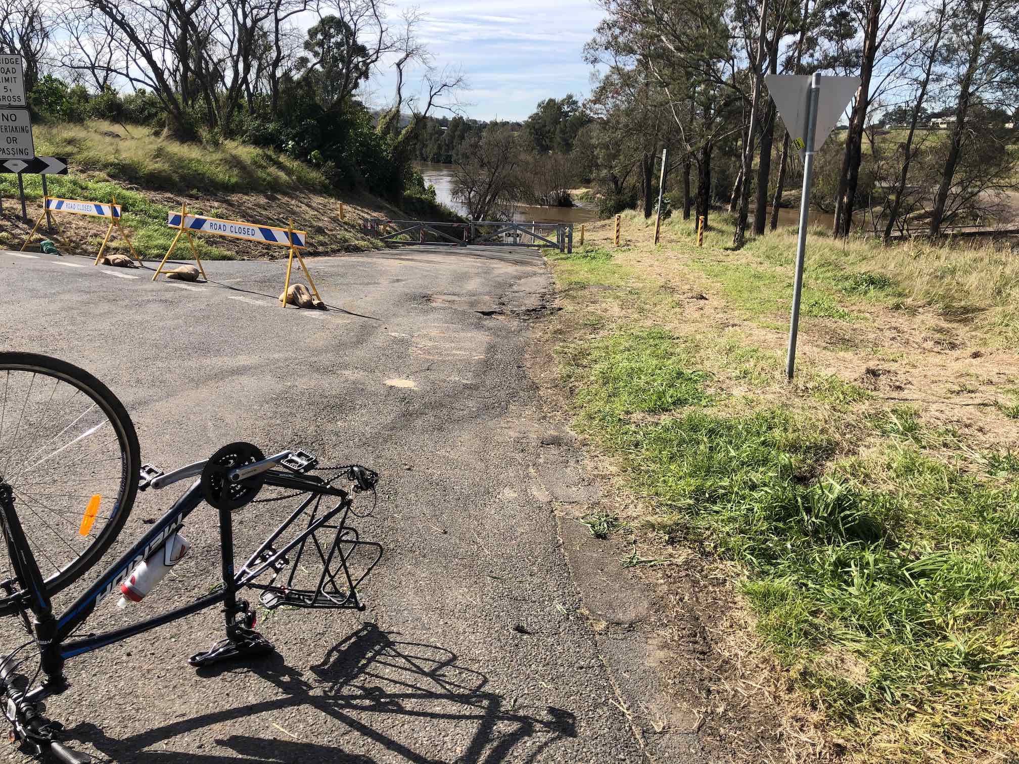 Bike upside down, with wheels removed, next to Melville Ford Bridge.