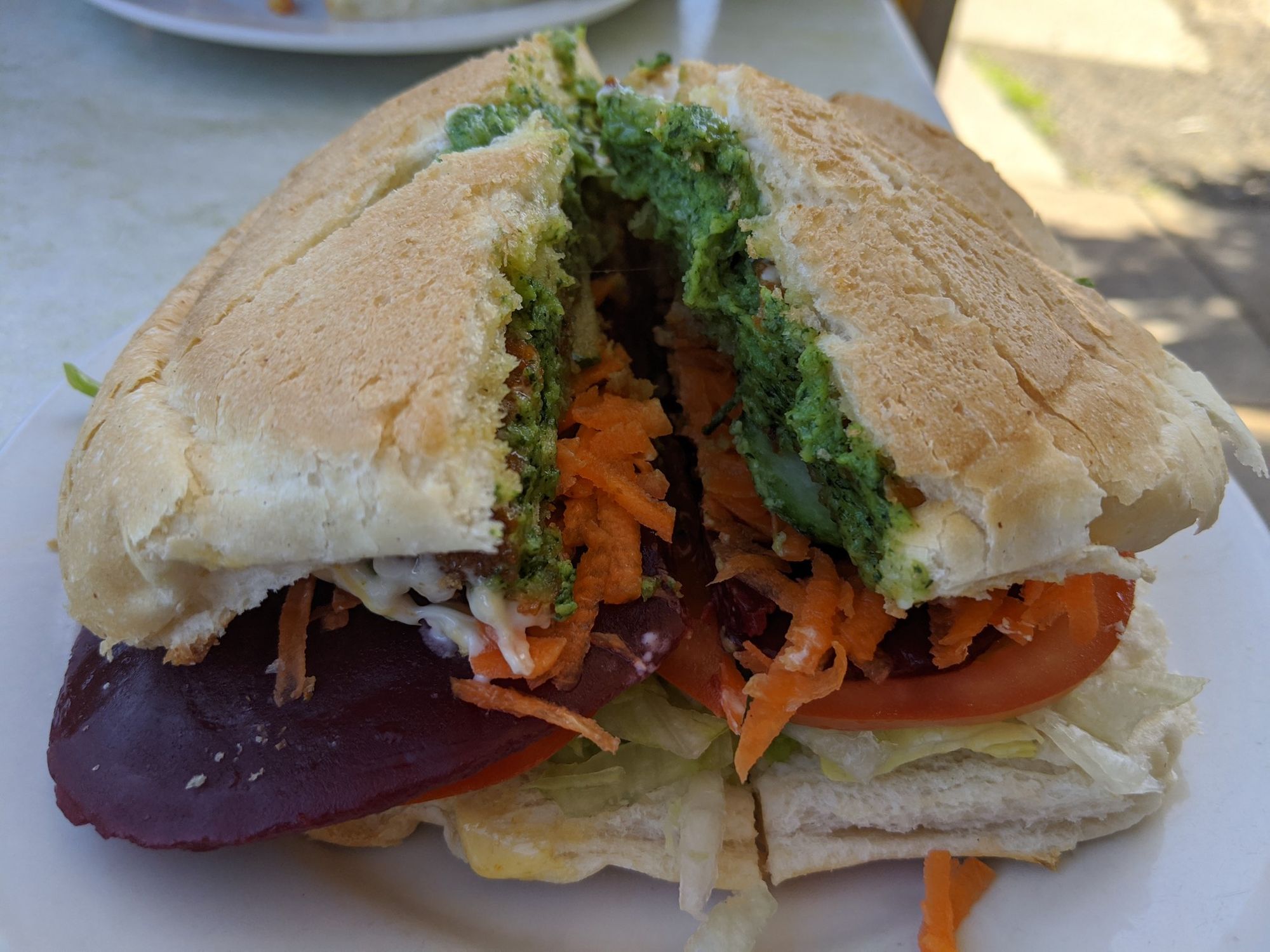 Vegetarian burger, cut in half, beetroot, carrot, lettuce, spinach/feta patty.