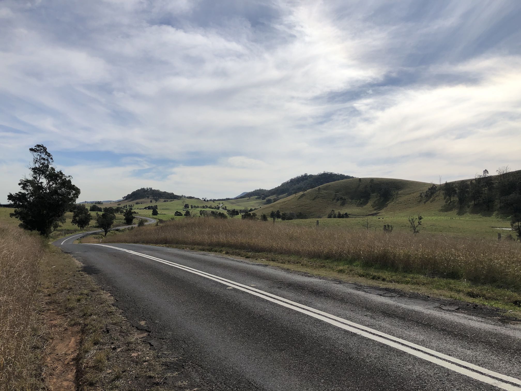 Road winding into the distance, with rolling green hills.