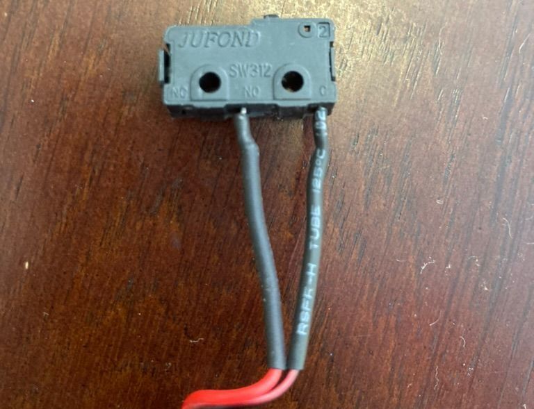Black box switch with tiny button at top; says JUFOND SW312, two wires coming out bottom